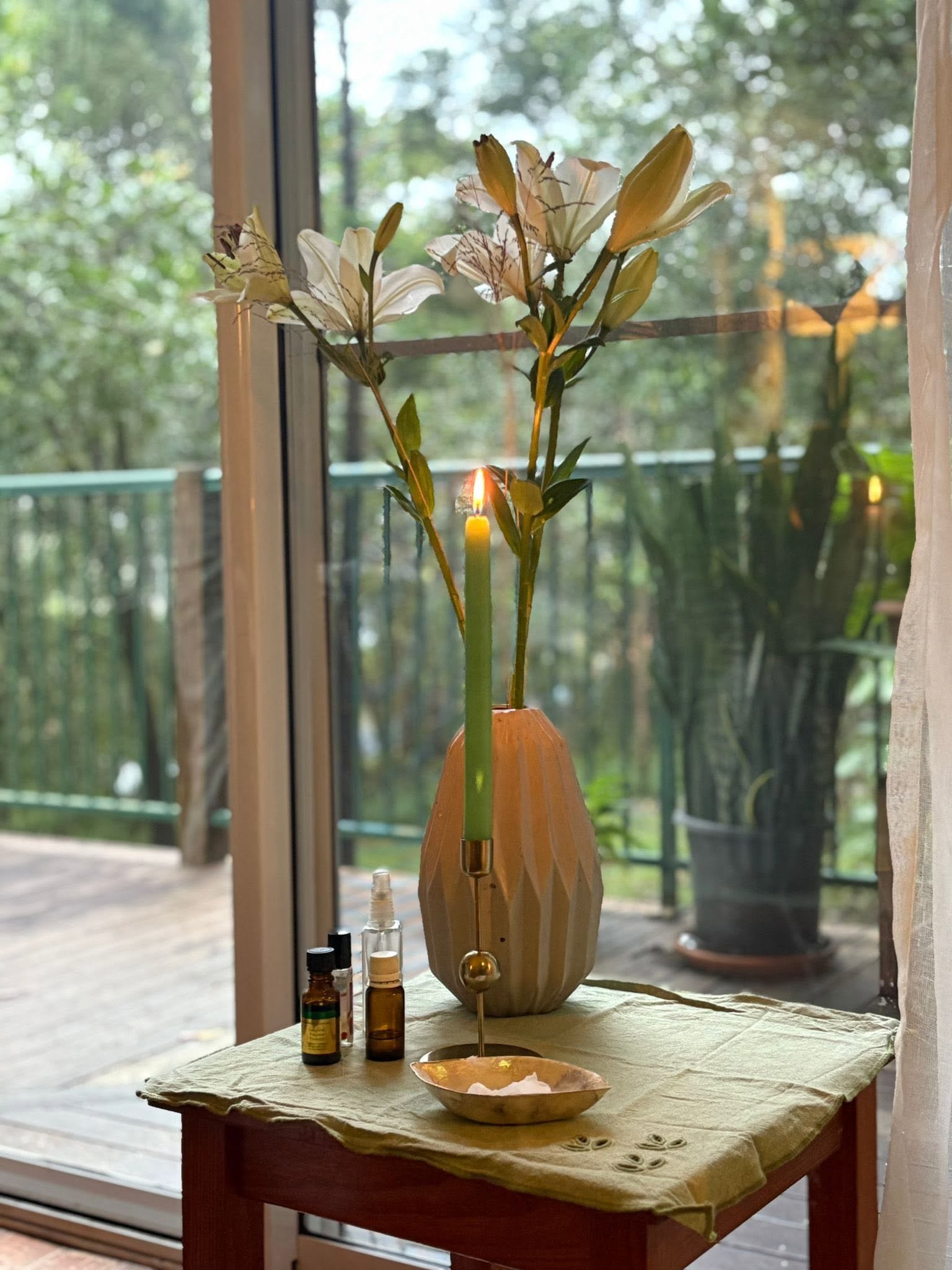 Calm spa setup with lilies and candlelight by a window